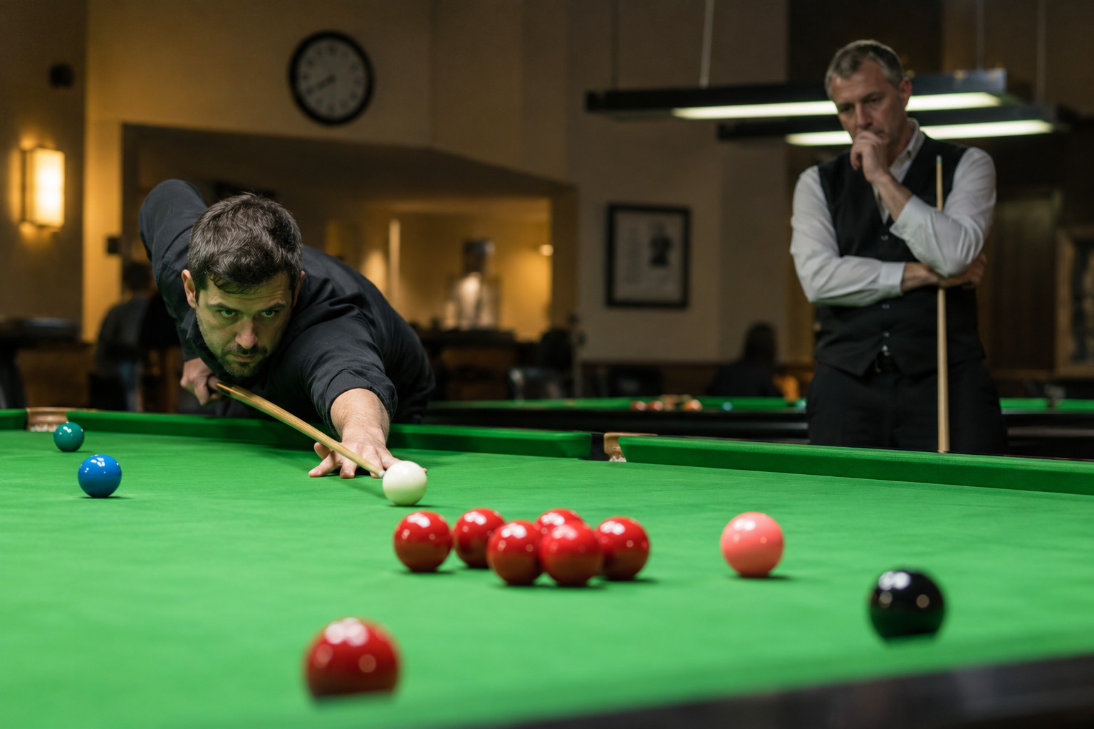 Snooker player lining up a shot while another waits near a wall clock