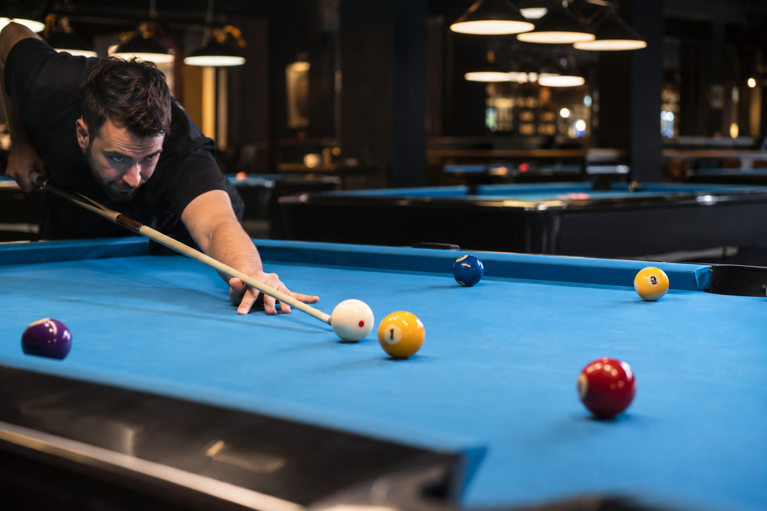 Player lining up a shot on the one ball during a nine-ball game