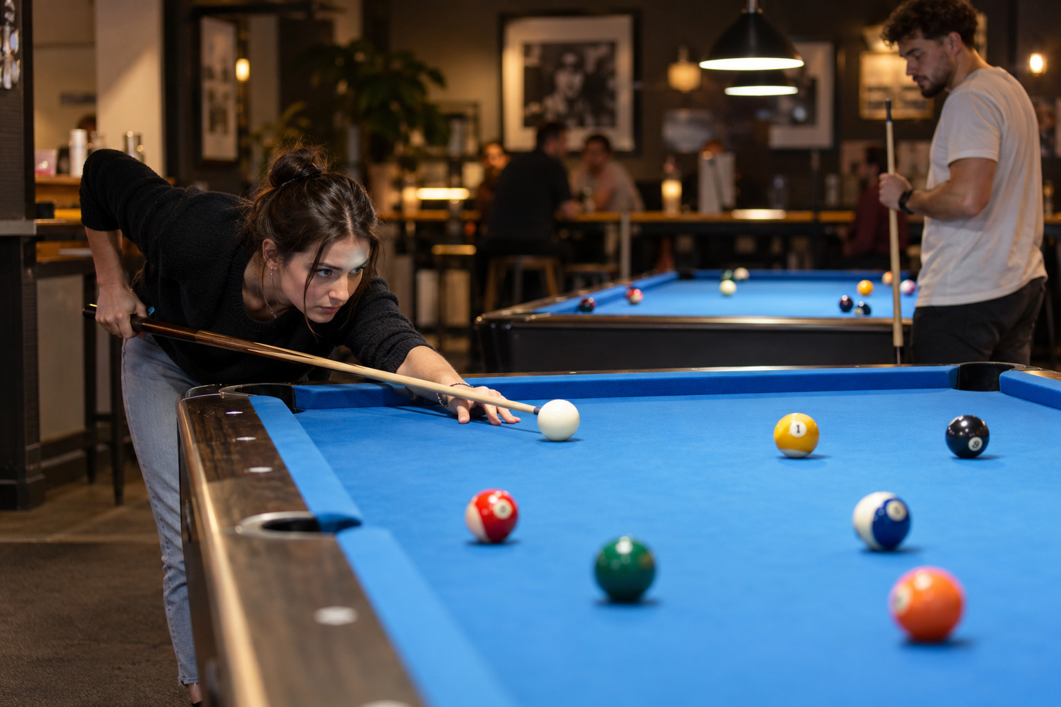 Player lining up a shot on a standard six-pocket pool table